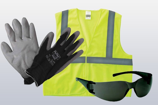 safety gloves, safety vest and safety glasses on a grey background